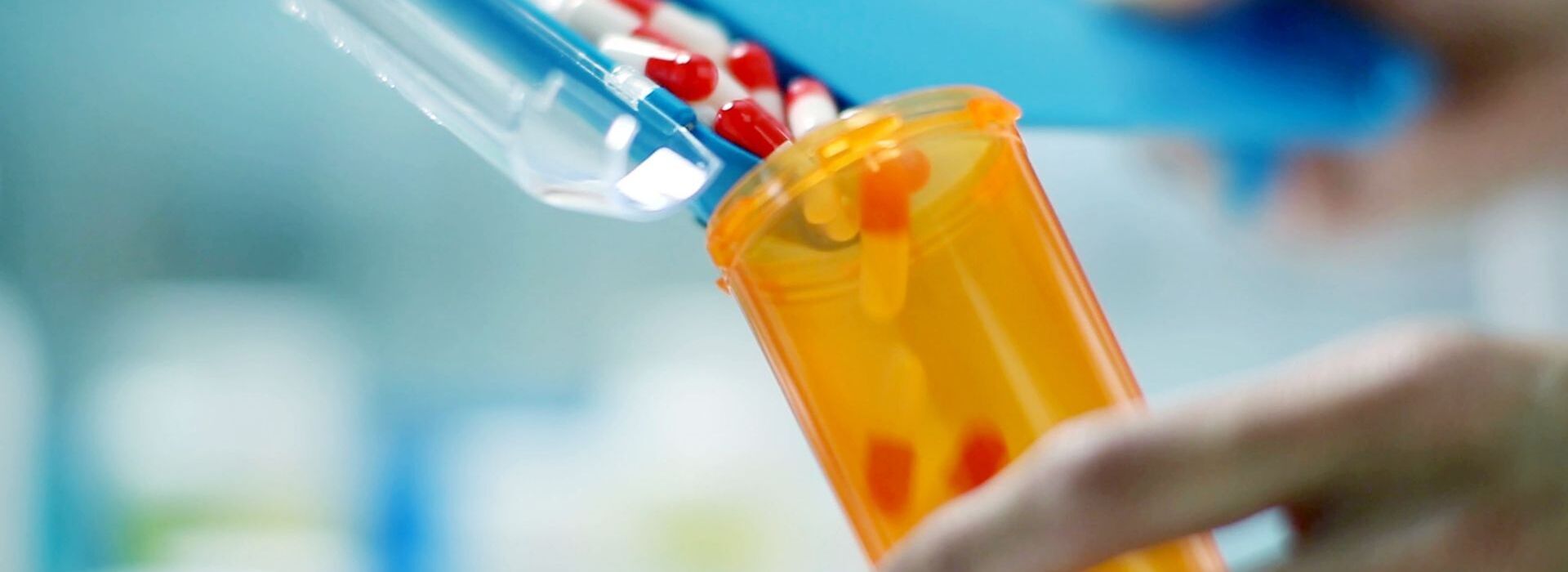 person filling pill bottle